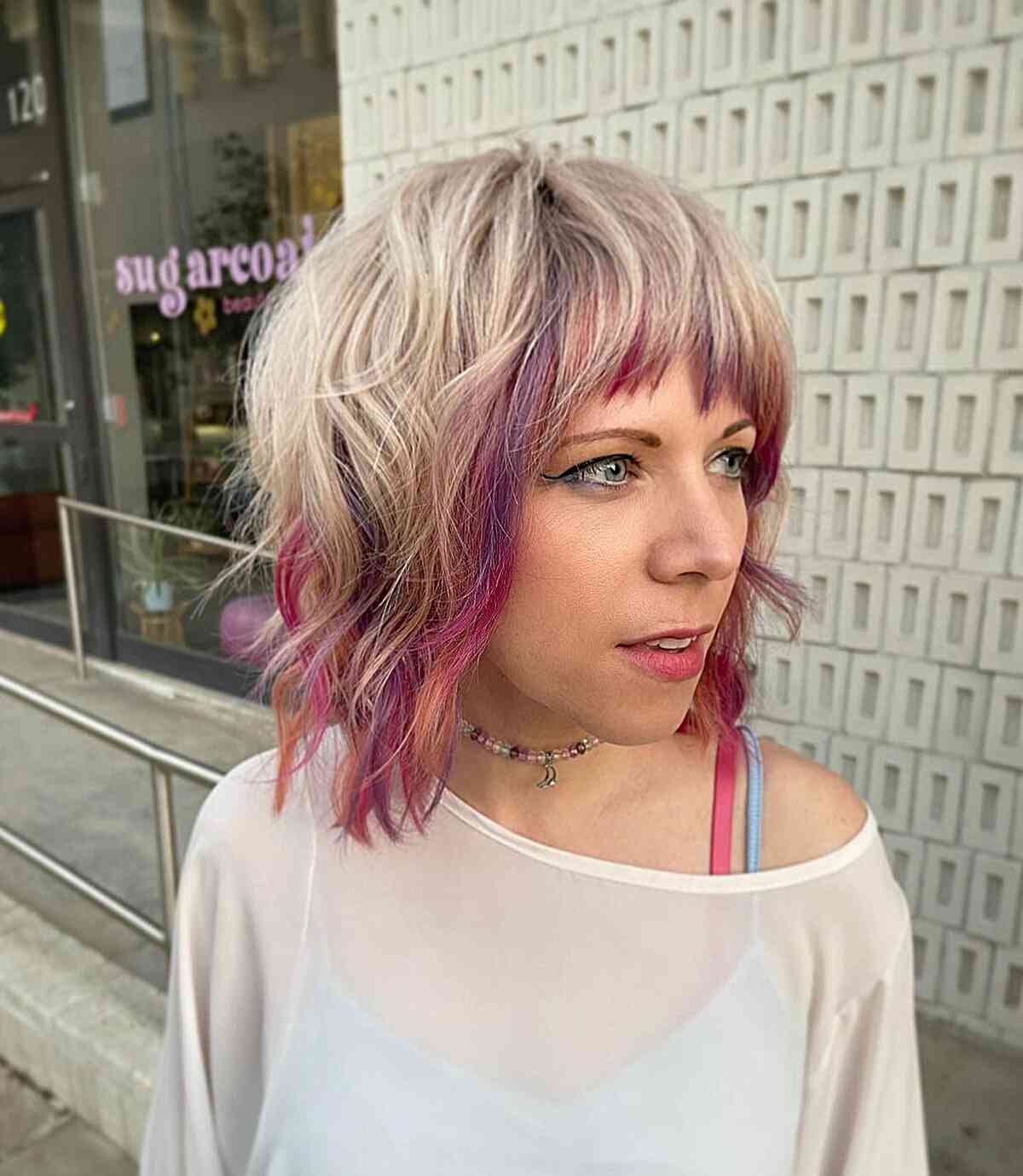 Face-framing peekaboo pink highlights for blonde hair