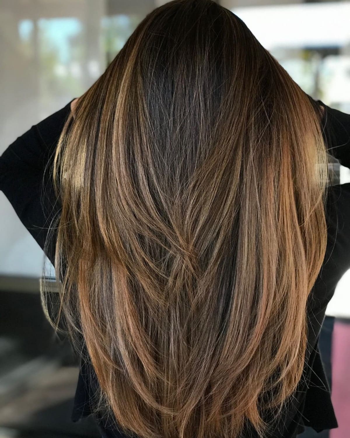 Feminine golden brown highlights on black hair