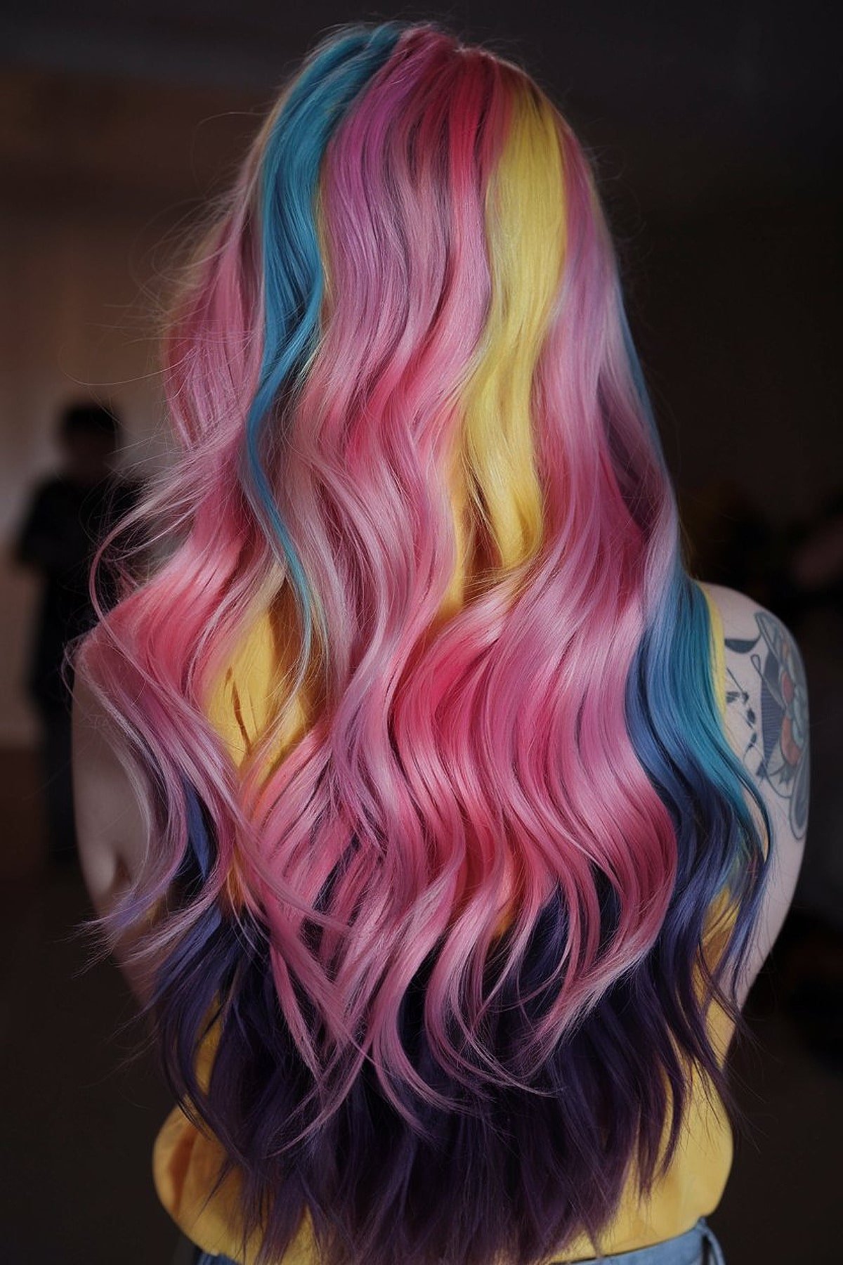 Long pastel hair in pink, yellow, blue, and purple shades with loose waves