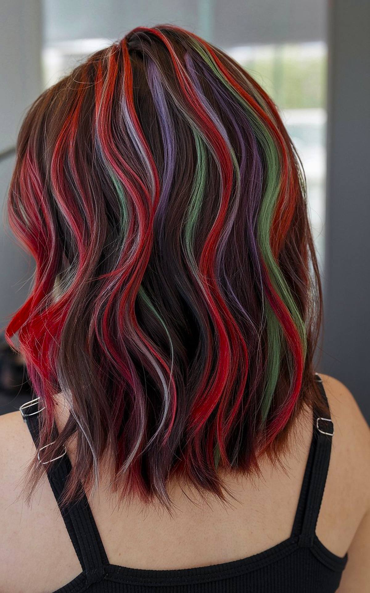 Christmas hair color idea for dark hair with red, green, and purple streaks