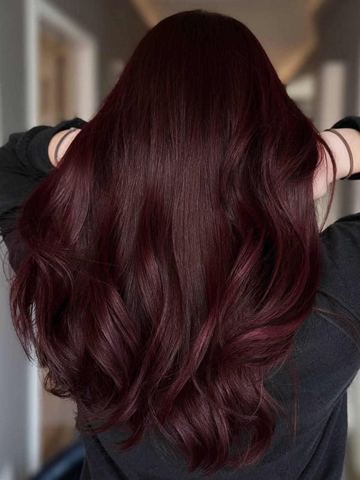 Dark burgundy red tone on long wavy hair