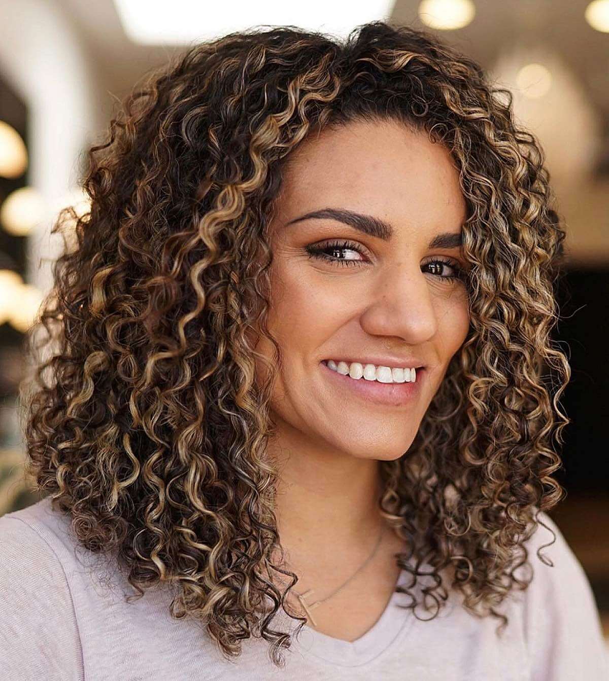 healthy warm blonde balayage on curly hair